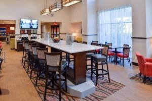 a lobby with a large bar with stools at Hampton Inn & Suites California University-Pittsburgh in Coal Center