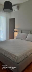 聖貝內代托德爾特龍托的住宿－Appartamento San Francesco 15，卧室内的一张白色大床,配有灯