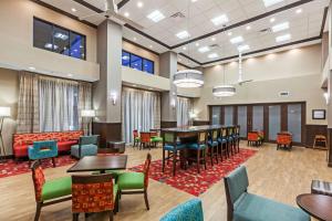 un vestíbulo con mesas, sillas y un piano en Hampton Inn & Suites Claremore, en Claremore