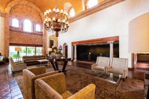 a living room with a chandelier and a table and chairs at Hilton San Luis Potosi in San Luis Potosí