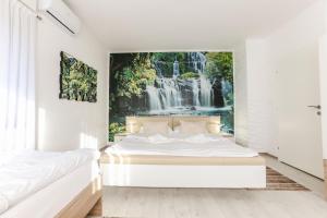 a bedroom with a waterfall mural on the wall at Holiday Home Ajna in Bihać