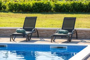 zwei Stühle neben einem Pool in der Unterkunft VILLA DOLA near Split - private pool, orchard, peace in Dicmo