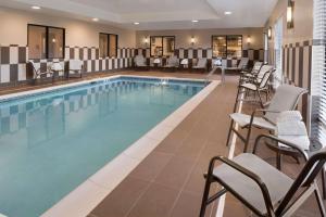 una piscina de hotel con sillas, mesas y sillas en Hampton Inn Lincoln Airport, Ne, en Lincoln