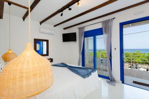 a bedroom with a bed and a large window at Apágkio Filoxenia in Archangelos