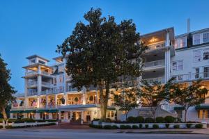 奥古斯塔奥古斯塔鹧鸪宾馆 - 希尔顿Curio Collection酒店的一座白色的大楼，前面有一棵树