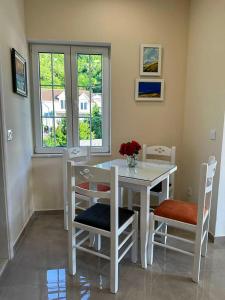 Sunčana Kula في هرسك نوفي: غرفة طعام مع طاولة بيضاء وكراسي