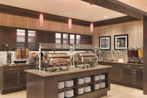 a restaurant kitchen with a counter with dishes at Homewood Suites by Hilton West Des Moines/SW Mall Area in West Des Moines