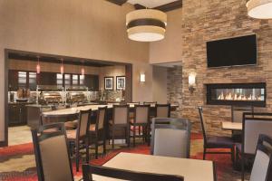 a restaurant with tables and chairs and a fireplace at Homewood Suites by Hilton West Des Moines/SW Mall Area in West Des Moines