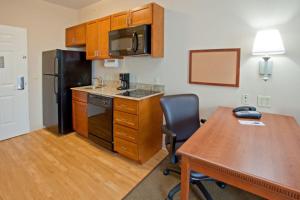 eine Küche mit einem Tisch, einem Kühlschrank und einem Schreibtisch in der Unterkunft Candlewood Suites League City, an IHG Hotel in League City