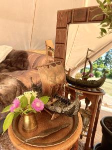 a table with a vase of flowers and a mirror at Sörby Glamping in Klockrike