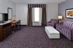 a hotel room with a couch and a tv at Hilton Garden Inn Hobbs in Hobbs