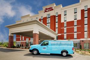 una furgoneta azul estacionada frente a un hotel en Hampton Inn & Suites Greenville Airport, en Greenville