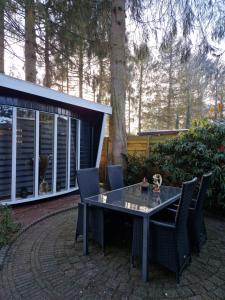 uma mesa e cadeiras sentadas num pátio em Chalet in Putten em Putten