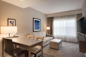 a living room with a couch and a table in a room at Embassy Suites by Hilton Kansas City Olathe in Olathe