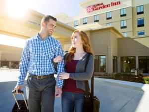 Ein Mann und eine Frau stehen vor einem Krankenhaus. in der Unterkunft Longview Hilton Garden Inn in Longview