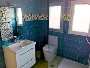 ein blau gefliestes Bad mit WC und Waschbecken in der Unterkunft Charmant appartement, T2 50m2, à Biguglia in Biguglia