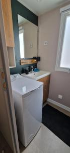 a bathroom with a sink and a toilet and a mirror at Mobilhome Camping la Carabasse Vias in Vias
