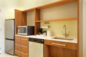 una pequeña cocina con fregadero y nevera. en Home2 Suites by Hilton Minneapolis Bloomington en Bloomington