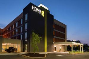 a hotel with a sign on the front of a building at Home2 Suites by Hilton Atlanta South/McDonough in McDonough