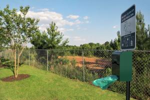 a parking meter next to a fence with a speed limit sign at Home2 Suites by Hilton Atlanta South/McDonough in McDonough