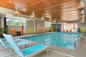una gran piscina con sillas y una mesa en Home2 Suites by Hilton Atlanta South/McDonough, en McDonough