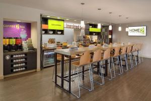 un restaurante con un bar con sillas en una tienda en Home2 Suites by Hilton Atlanta South/McDonough, en McDonough