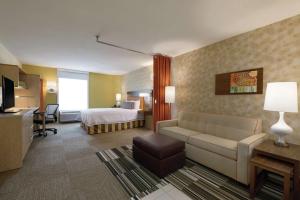 a hotel room with a bed and a couch at Home2 Suites by Hilton Atlanta South/McDonough in McDonough