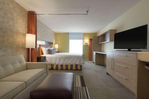 a hotel room with a bed and a television at Home2 Suites by Hilton Atlanta South/McDonough in McDonough