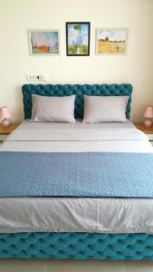 un grande letto con testiera blu e cuscini di Kristi Lux Jezero - NEW Studio apartment with Balcony and FREE Parking a Veliko Gradište