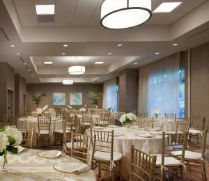 a banquet hall with tables and chairs and flowers at Hilton Garden Inn Miami Dolphin Mall in Miami