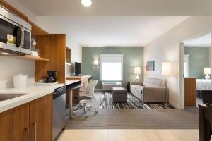 a hotel room with a kitchen and a living room at Home2 Suites by Hilton Milton Ontario in Milton