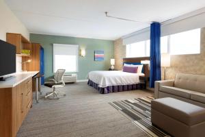 een hotelkamer met een bed en een bank bij Home2 Suites by Hilton Milton Ontario in Milton