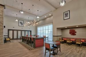 a lobby with a bar and tables and chairs at Hampton Inn & Suites Artesia in Artesia