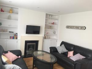 a living room with two black couches and a fireplace at NEW 2BD Flat Heart of Battersea - Close to Station in London