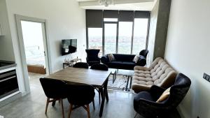 sala de estar con sofá, mesa y sillas en Ultra Lux full Residence with balcony near to Bomonti Hotel, en Estambul