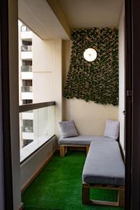 Habitación con 2 bancos y alfombra verde. en 96 Hostel Dubai en Dubái