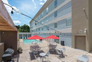 a patio with tables and chairs and red umbrellas at Home2 Suites by Hilton Lake City in Lake City