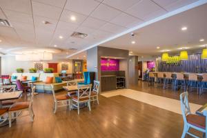 a restaurant with tables and chairs and a bar at Home2 Suites by Hilton Lake City in Lake City