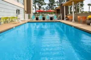 una grande piscina blu con sedie e tavoli di Home2 Suites by Hilton Lake City a Lake City