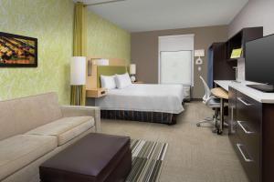 レイク・シティにあるHome2 Suites by Hilton Lake Cityのベッドとソファ付きのホテルルーム