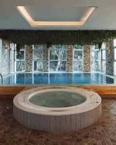 a large swimming pool in a building with a large window at Boutique Hotel & Spa Bosque del Nahuel in San Carlos de Bariloche