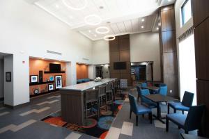 a lobby with tables and chairs and a bar at Hampton Inn & Suites Stillwater West in Stillwater