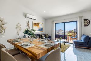 a dining room with a wooden table and a living room at Morgan Residences 607A in Cabo San Lucas