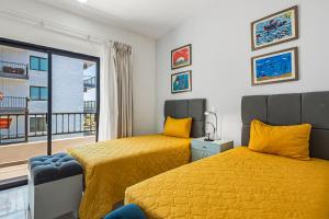 a bedroom with two beds and a balcony at Morgan Residences 607A in Cabo San Lucas +26 photos