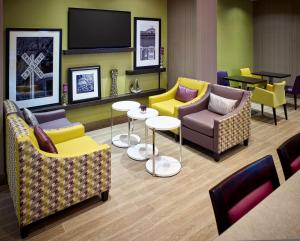 una sala de espera con sofás, mesas y TV en Hampton Inn by Hilton Sarnia/Point Edward, en Point Edward