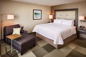 um quarto de hotel com uma cama e uma cadeira em Hampton Inn by Hilton Sarnia/Point Edward em Point Edward