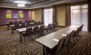 Hampton Inn by Hilton Sarnia/Point Edward في Point Edward: قاعة اجتماعات مع طاولات وكراسي خشبية