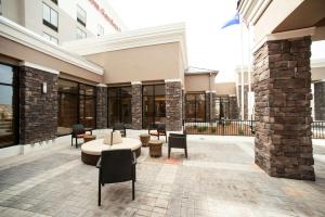 Hilton Garden Inn San Antonio-Live Oak Conference Center في سان انطونيو: ساحة مع كراسي وطاولات في مبنى