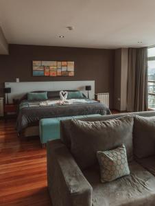 una grande camera da letto con un letto e un divano di Boutique Hotel & Spa Bosque del Nahuel a San Carlos de Bariloche