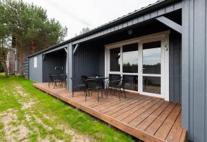 a deck with chairs and a table on a house at Paukšcių takas Vertikalė poilsio namai in Šventoji